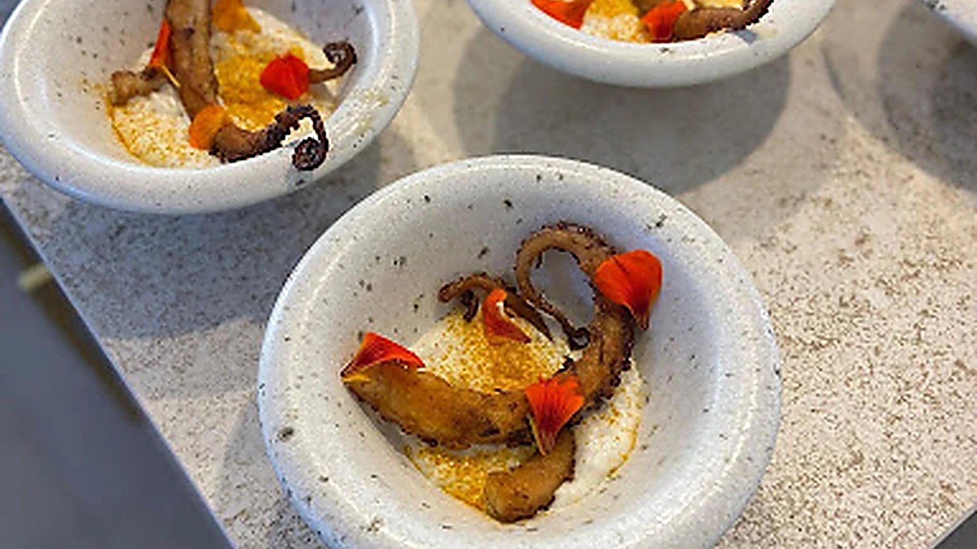 Individual octopus courses with edible flowers prepared for an event
