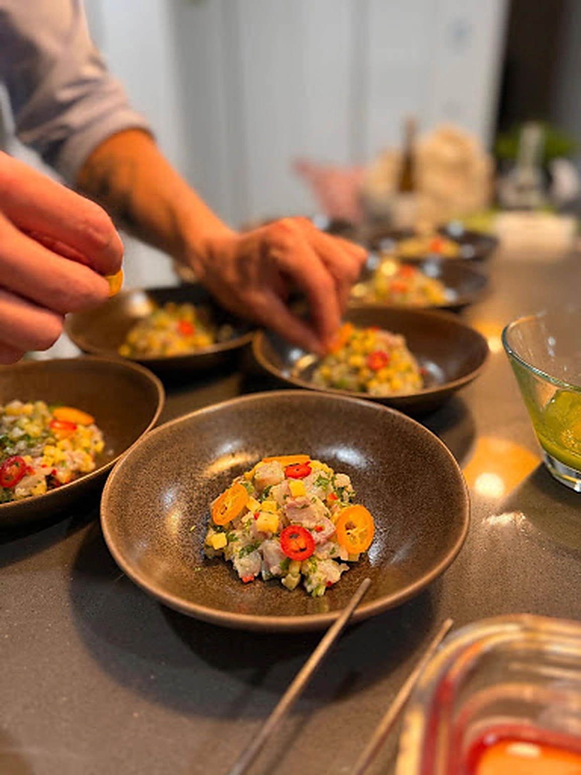 A chef garnishing individual tartare courses during event service