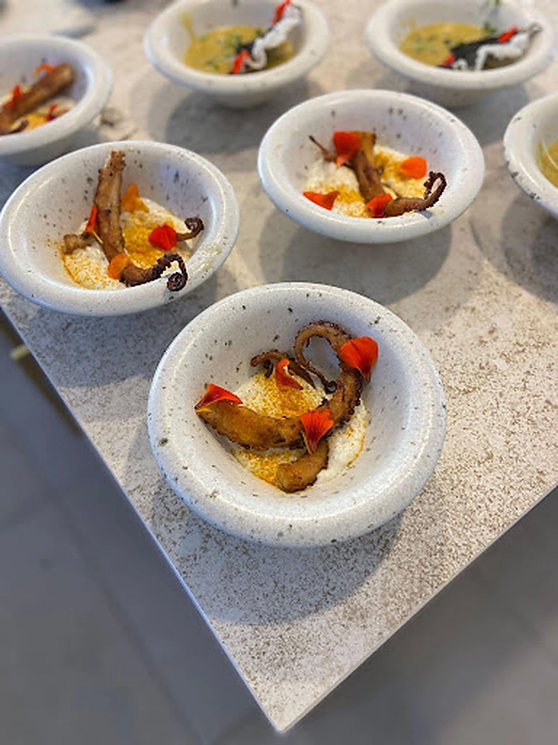 Individual octopus courses with edible flowers prepared for an event